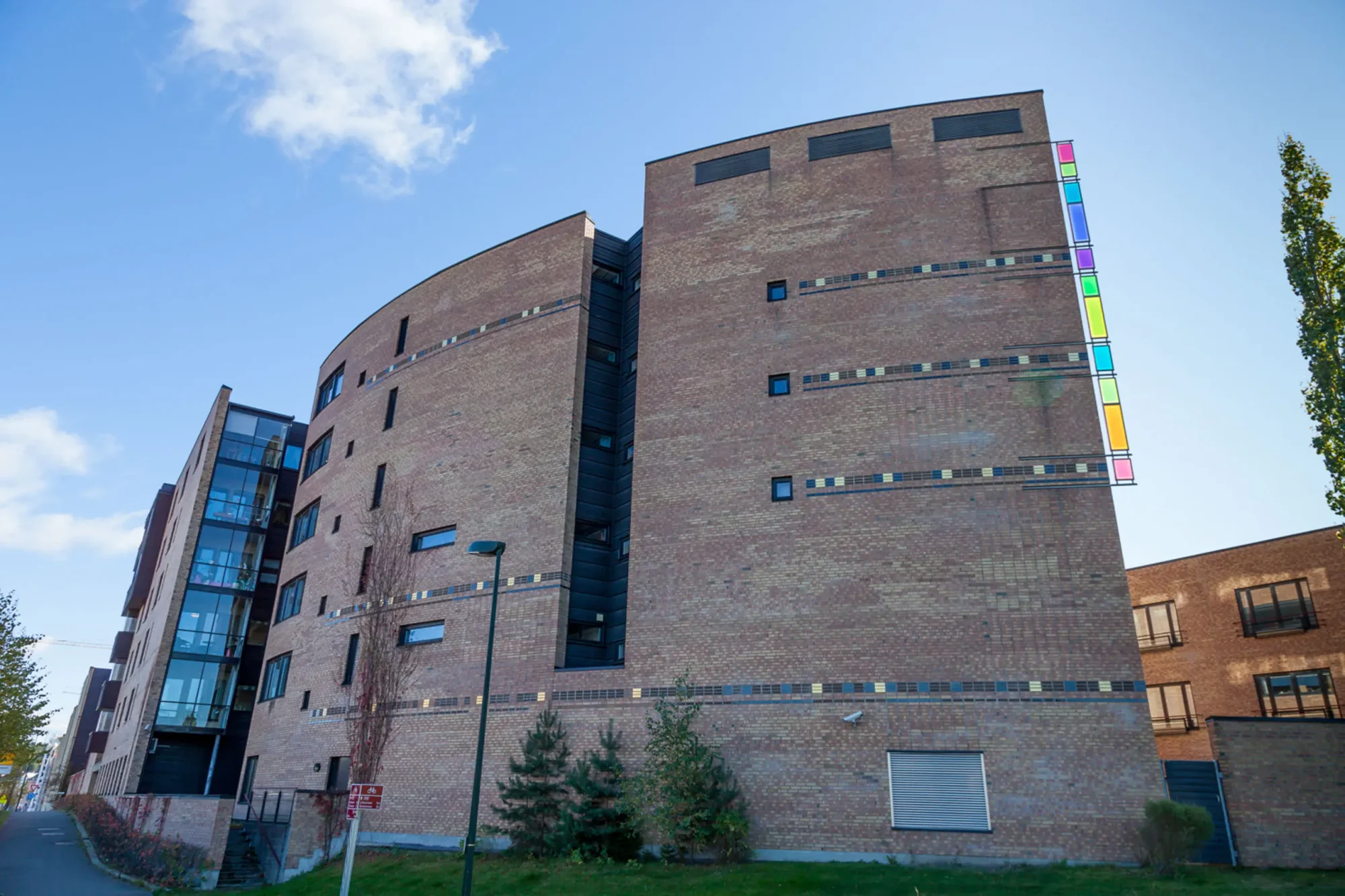 rolvsrudhjemmet, sykehjem og omsorgsboliger. Fasade i lys brun tegl og detaljer i varierte farger.