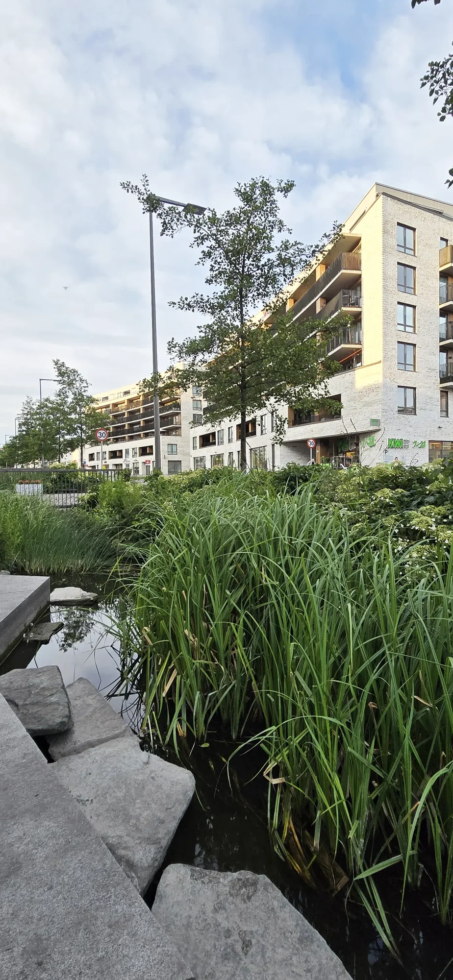 Locus Ensjø, Gladengveien. Fasaden har lys tegl i kombinasjon med malt panel og lys platekledning. Bygningen er buet mot Ellipseplassen. Bygningene leker med form og dybde, med utkragede balkonger, og inntrukne partier.