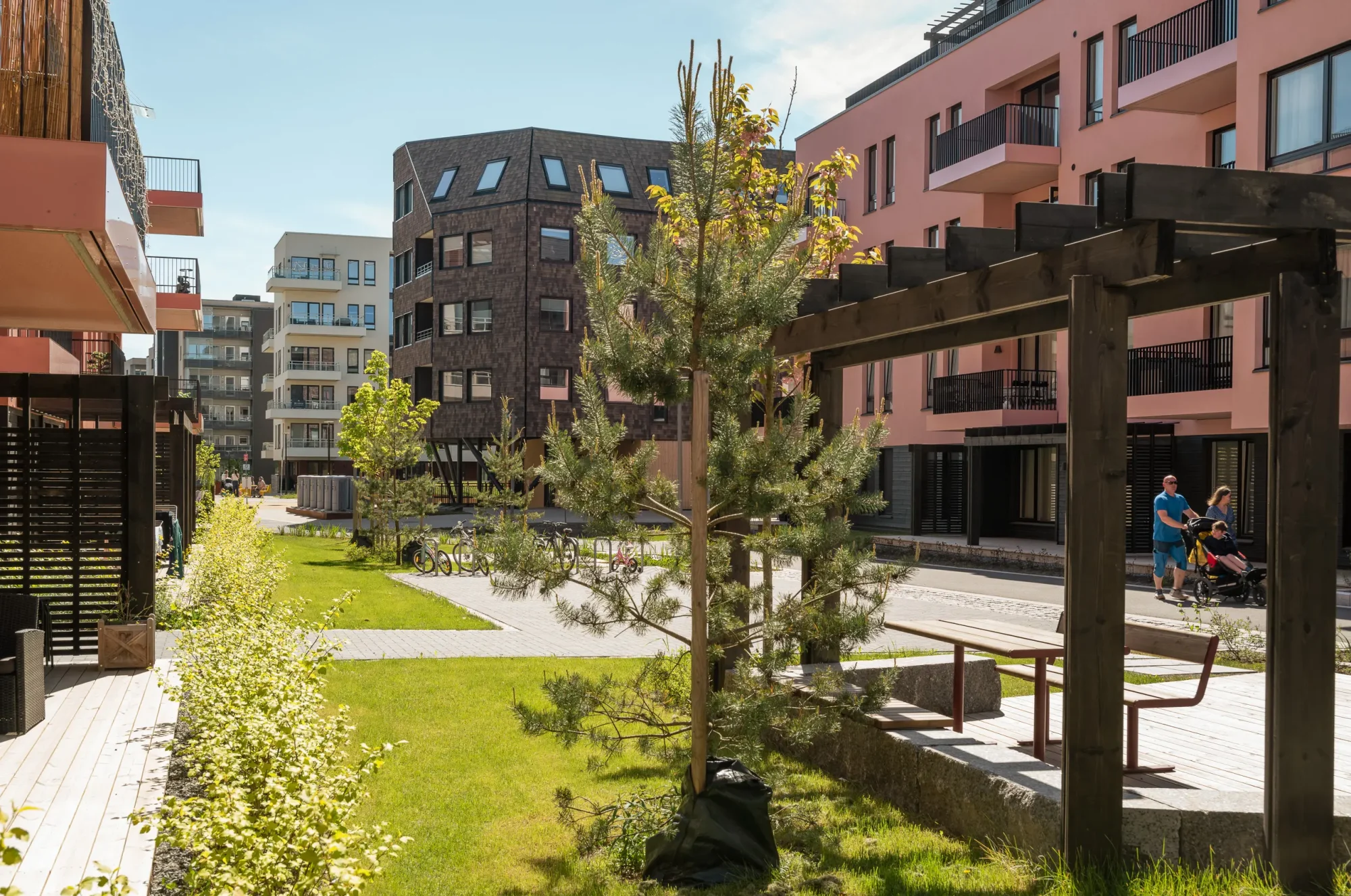 Gårdskvartalet med barnehage på Skårer skårerbyen. fasadene har hvit og rød/ rosa puss, farget balkongrekkverk, og farget beslag på dekkeforkanter, slik at balkongene i større grad er en del av fasadelivet, og gir et skulpturelt uttrykk. Utearealet er grønt og frodig. Kongla skiller seg ut med mørk brun skjermtegl.
