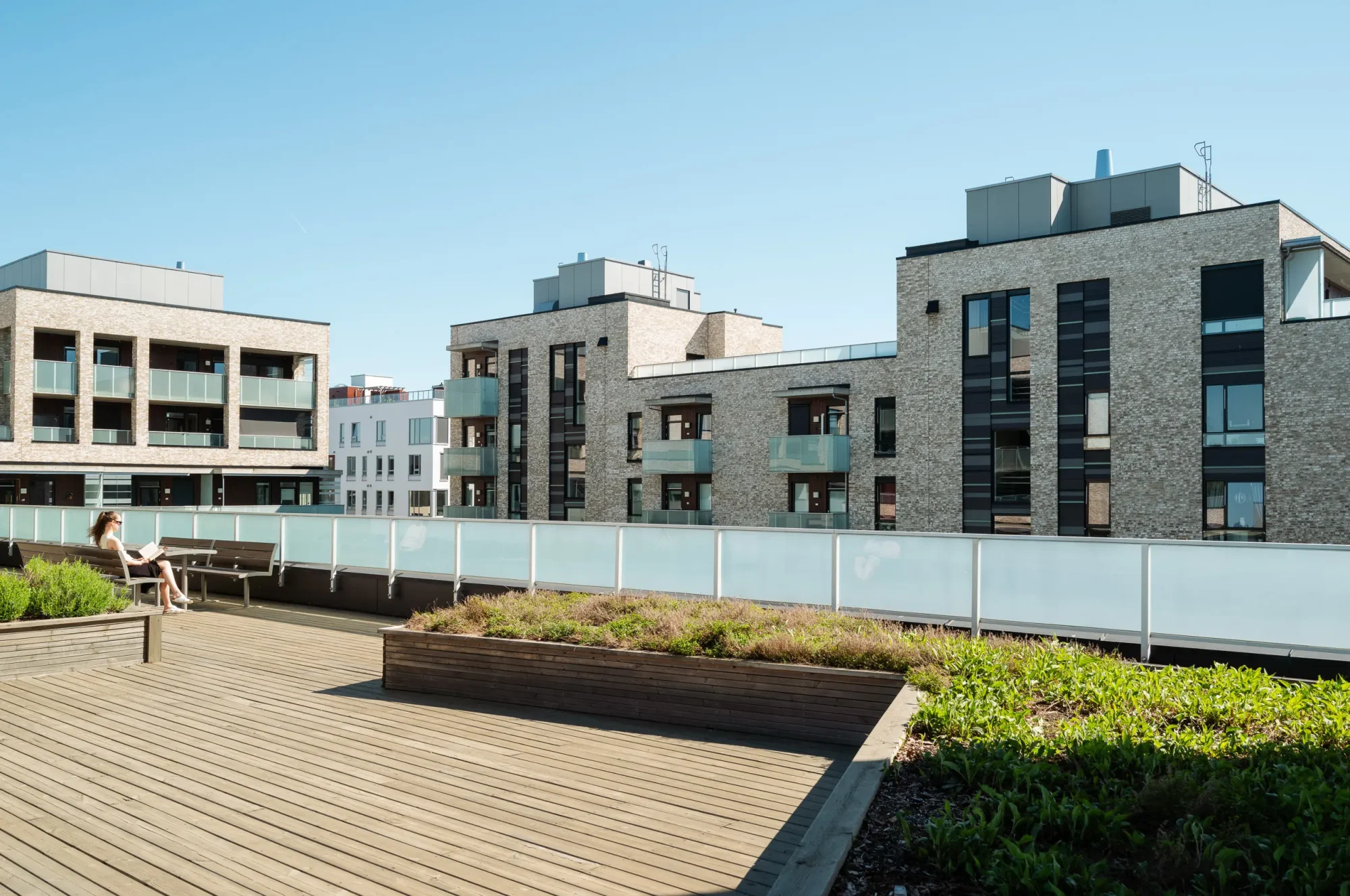 Engebrets promenade, Lillestrøm. Her finnes åpne tilgjengelige torg, og offentlig passasje gjennom kvartalet. Fasadene er utført med lys tegl, sort platekledning, og inntrukne og utkragede balkonger med foliert glassrekkverk som gir varierte dybder og interessant skyggespill.