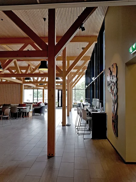 tyrili, skien har administrasjon og fellesarealer i plan 1. Her finnes en storstue, med god takhøyde, og synlig limtrekonstruksjon, som gir rommet varme, og refererer til store trekroner, samt den historiske tømmervirksomheten på klosterøya.