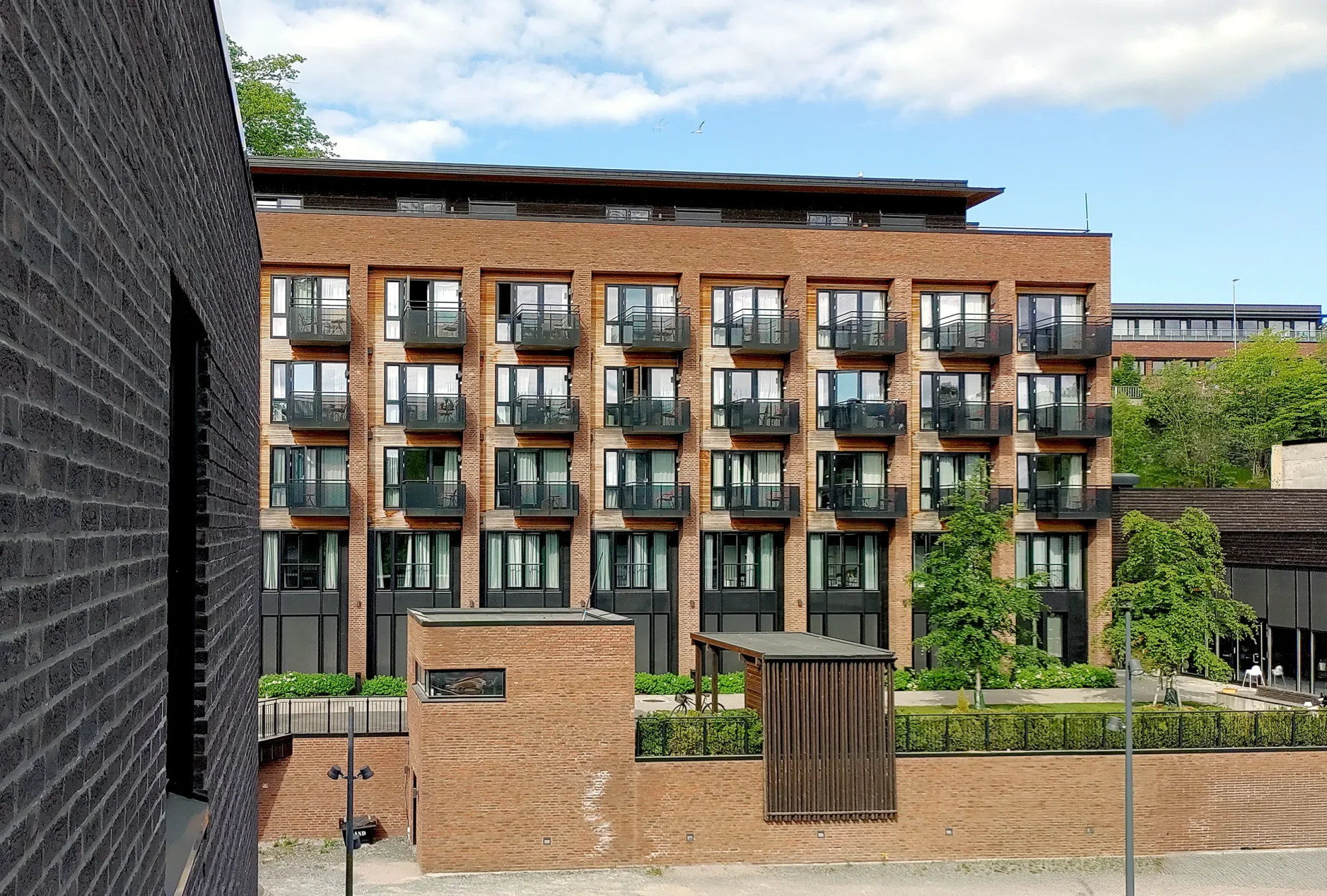 tyrili skien, senter for rehabilitering av rusavhengighet. rusomsorg. tydelige teglpilastre, varmt trekledning og sorte detaljer i stål og perforerte plater.