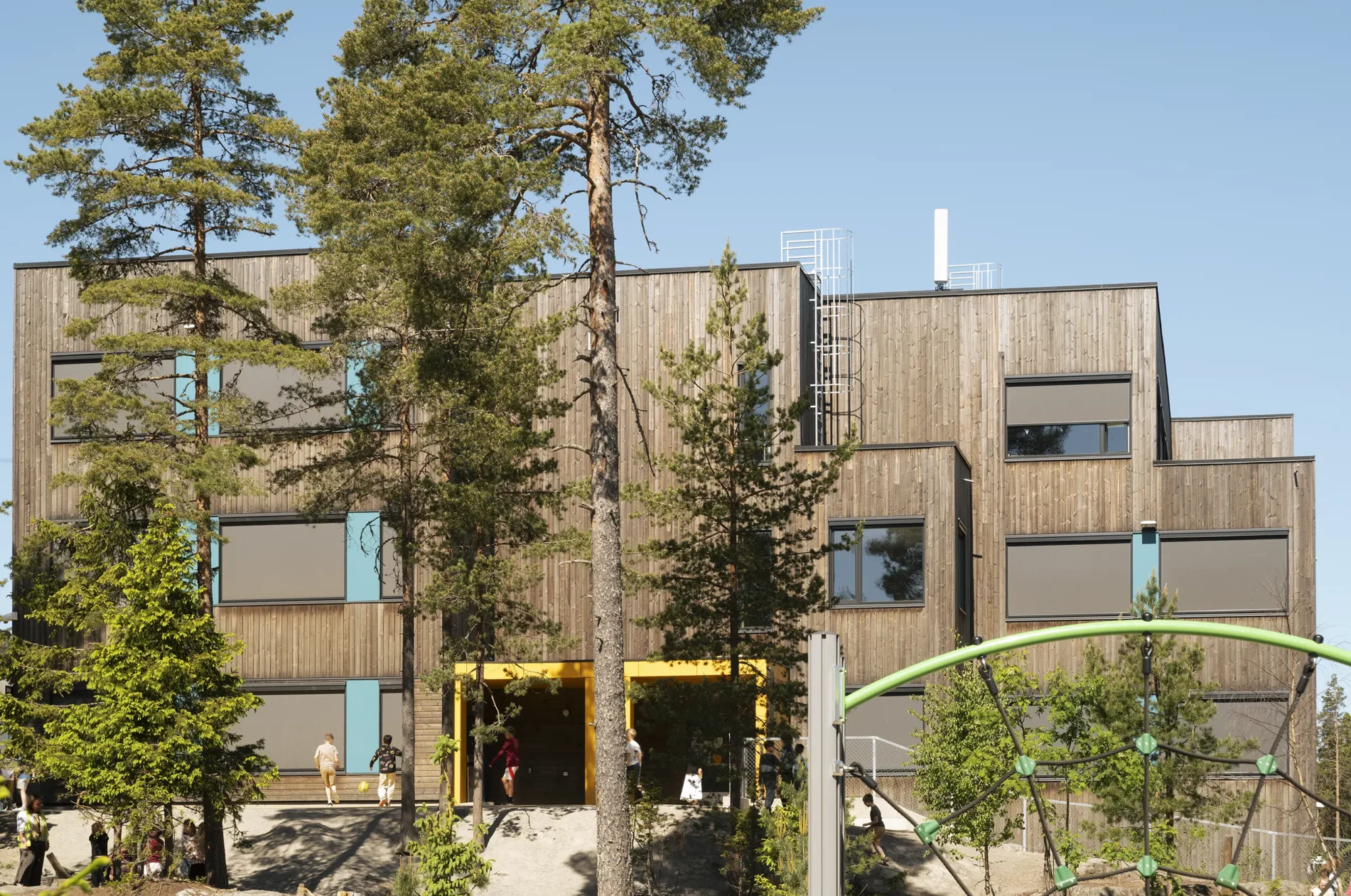 Fjerdingby skole, beliggende i en skog, der vegetasjonen er bevart og ligger helt inntil bygningskroppen. Fasader er utført i behandlet treverk, og har vindusbånd med farget plater i primærfarger, og tydelige innganger.