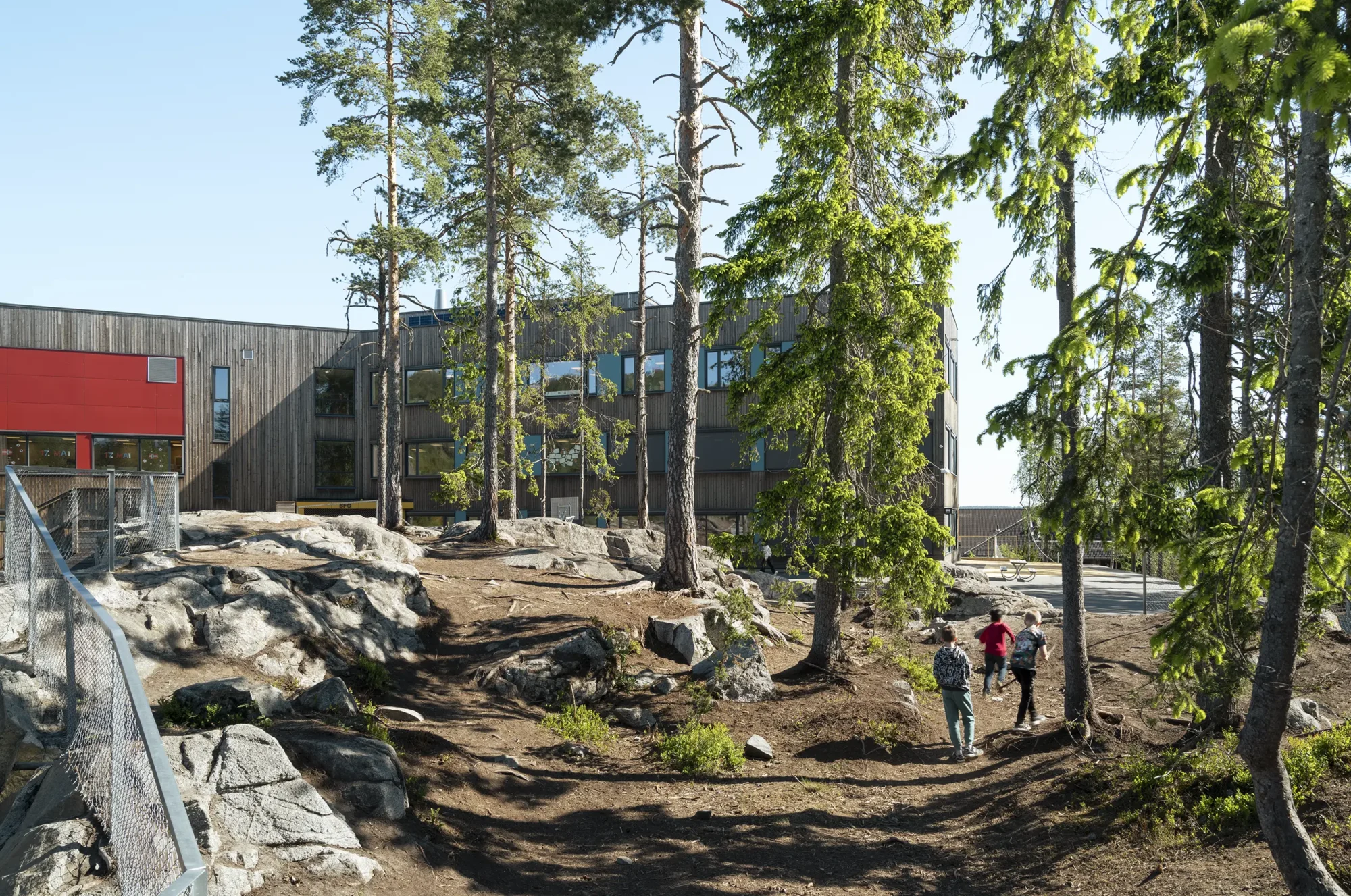 Fjerdingby skole, beliggende i en skog, der vegetasjonen er bevart og ligger helt inntil bygningskroppen. Fasader er utført i behandlet treverk, og har vindusbånd med farget plater i primærfarger, og tydelige innganger.